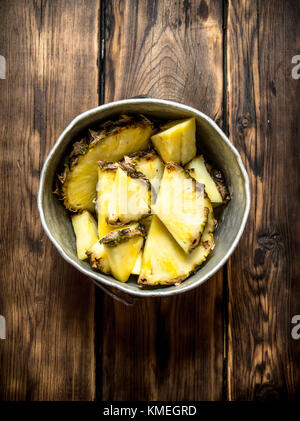 Scheiben Ananas in einem Topf. Auf einem Holztisch. Stockfoto