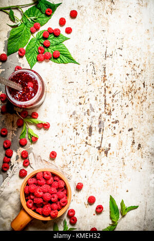 Die Marmelade mit Himbeeren und Minze. Auf rustikalen Hintergrund. Stockfoto