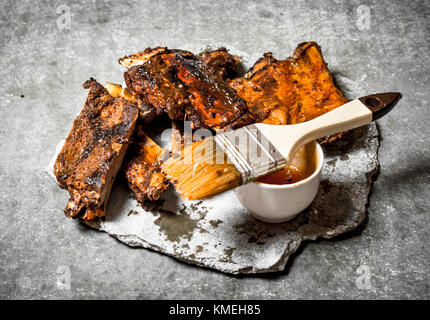 Rippchen vom Grill mit Tomatensauce. Auf einem Stein. Stockfoto