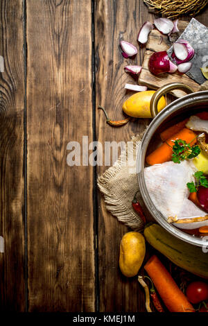 Zutaten zum Kochen Hühnersuppe mit Gemüse und Gewürzen. Auf einem Holztisch. Stockfoto