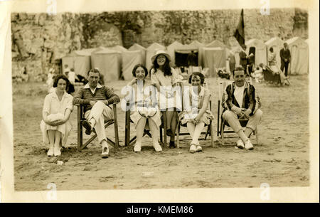 1920 s, historischen, happy holiday Family Portrait am Strand, das Kleid und Moden des Tages und Leinwand baden Zelte für Bescheidenheit hinter, England, UK. Stockfoto