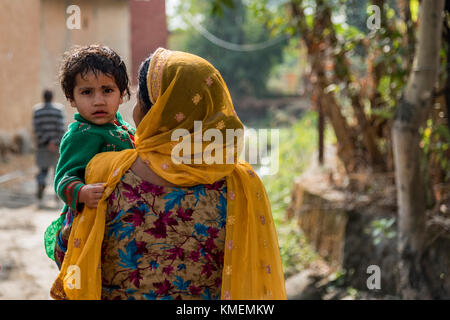 Eine indische Frau, die ein Baby in ihren Armen. Stockfoto
