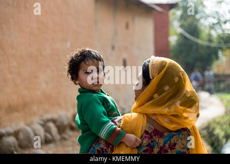 Eine indische Frau, die ein Baby in ihren Armen. Stockfoto