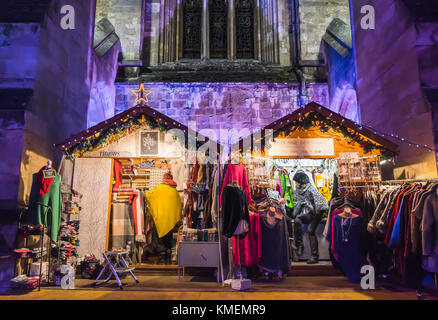 Lebendige Bunte Marktstände mit der beleuchteten Kathedrale von Winchester, die im Hintergrund an der Winchester Weihnachtsmarkt 2017, Winchester, England, Großbritannien Stockfoto