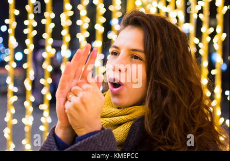 Mädchen Aufwärmen ihre Hände im Winter mit festlichen Hintergrund Stockfoto