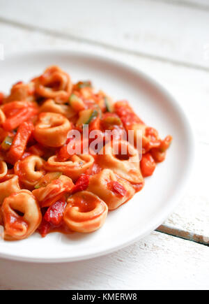 Tortellini primavera Parmesan in marinara Sauce auf Holz- rustikalen Hintergrund Stockfoto