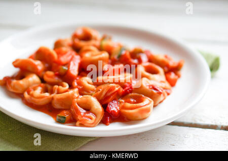 Tortellini primavera Parmesan in marinara Sauce auf Holz- rustikalen Hintergrund Stockfoto