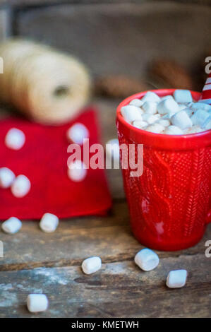 Rot gestrickt Becher mit heißer Schokolade und Marshmallows auf hölzernen Hintergrund Stockfoto