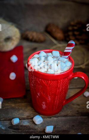 Rot gestrickt Becher mit heißer Schokolade und Marshmallows auf hölzernen Hintergrund Stockfoto