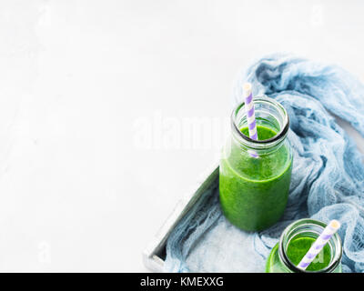 Gesunde Ernährung Konzept grüne Smoothies Frühstück auf Weiß Grau Fach blau Textil. obst gemüse saft Glas Flasche. top View Stockfoto