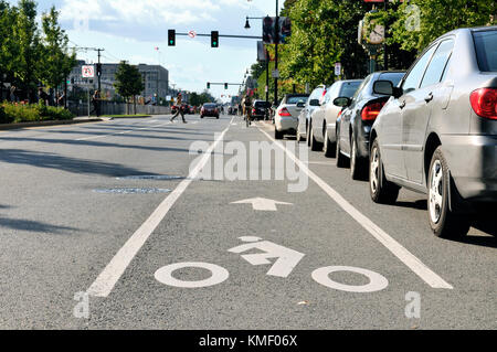 Radweg in Stadt Straße. Radfahrer Symbol auf Pflaster gemalt, Biker pendeln, Autos auf dem Parkplatz Gassen, Ampel, Kreuzung am Zebrastreifen Stockfoto