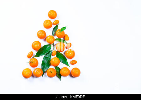 Weihnachtsbaum aus frischen Mandarine mit Blättern auf einem weißen Hintergrund. Reifen köstliche Frucht. Symbol für das Neue Jahr und Weihnachten Stockfoto
