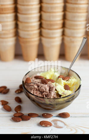 Melone- und Schokoladeneis mit Mandeln im Hintergrund Waffelbecher. Stockfoto