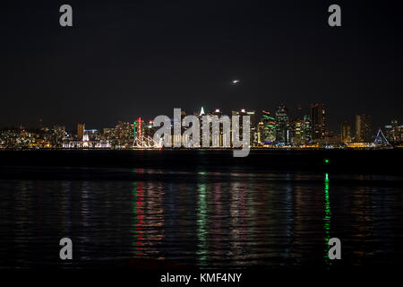 Ansicht der Metro San Diego von Shelter Island bei Nacht mit der Reflexion von Licht im Wasser Stockfoto