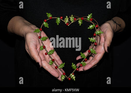 Frau Hände mit Mistel Kranz Weihnachten Ornament Stockfoto