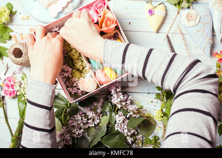 Schachtel mit Blumen und Makronen Stockfoto