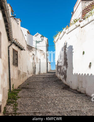 Die engen, kopfsteingepflasterten Gasse klettern zu den strahlend blauen, wolkenlosen Himmel unter traditionellen, weiß getünchten Häusern. Stockfoto