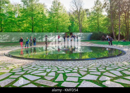 Roma Holocaust Berlin, Blick von Jugendlichen auf den reflektierenden Pool im Holocaust-Mahnmal Gypsy und Sinti, Tiergarten, Berlin, Deutschland. Stockfoto