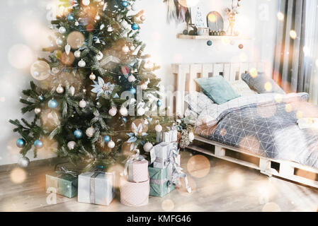 Wunderschönes Zimmer mit Weihnachtsbaum, darunter Geschenke. Frohes neues Jahr und Weihnachten. Bokeh-Effekt leicht weich. Stockfoto