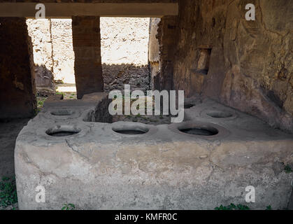 Ruinen der alten Küche in einem der Häuser in Pompeji, Italien. Das Foto zeigt einen alten Backofen mit sechs alten Kochplatten Stockfoto