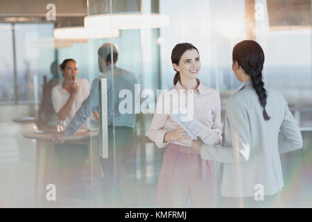 Unternehmerinnen mit Papierkram zu sprechen in Office Stockfoto