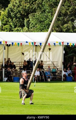 Lonach Highland Games am Strathdon, Grampian, Schottland, Vereinigtes Königreich. Konkurrent tragen traditionelle Kilt der Caber tossing Stockfoto