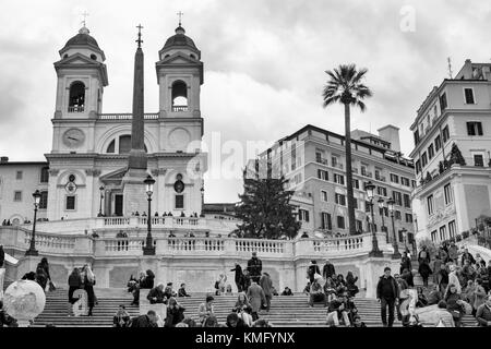 Rom, Italien, November 2017: Touristen saßen auf der Spanischen Treppe, Scalinata di Trinità dei Monti, einem der berühmtesten Treppenhäuser in Welt oberhalb der Piazza di Spagna und der Kirche Santissima Trinità dei Monti. Stockfoto