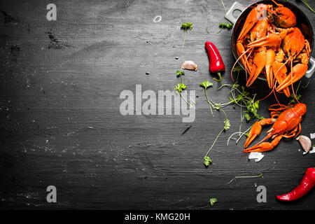 Das Essen Delikatessen. gekochte Languste mit Kräutern und würziger Paprika. Auf einer schwarzen Tafel. Stockfoto