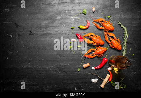 Gekochte Languste mit Weißwein und Gewürzen. Auf einer schwarzen Tafel. Stockfoto