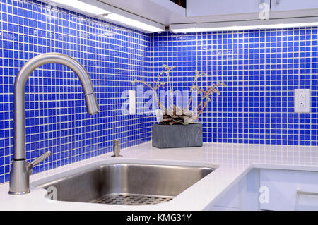 Blau backsplash Tiles, weiß Arbeitsplatte, einzigen Griff Küche Wasserhahn. moderne Home Interior Design und Dekor Stockfoto