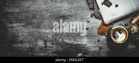 Gebrühten Kaffee Topf mit frischen Zeitung und bittere Schokolade. Auf schwarzem Hintergrund im Landhausstil. Stockfoto