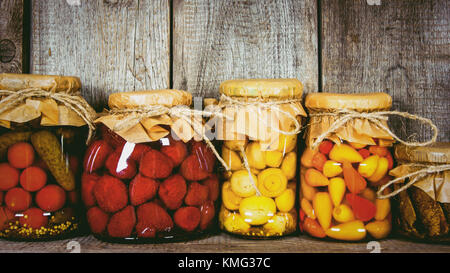 Haltbar gemachten Lebensmitteln in Gläsern, auf einem Holzregal. Verschiedene gebeizt Essen Stockfoto