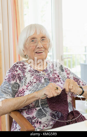 Ältere Frau in Ruhe zuhause Häkeln Stockfoto