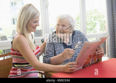 Ältere Frau liest mit ihrer Tochter Zeitung Stockfoto