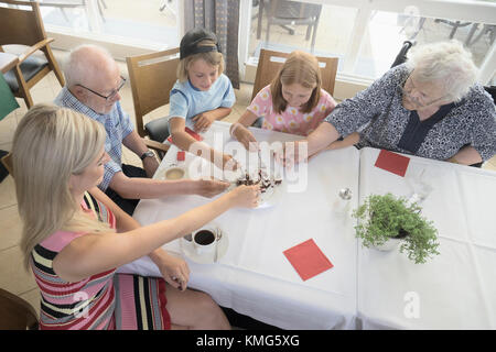 Großeltern essen flan Kuchen mit Enkelkinder und Tochter in Ruhe zu Hause Stockfoto