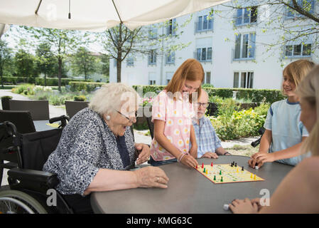 Multi-Generation, Familie spielen Brettspiel am Pflegeheim Stockfoto