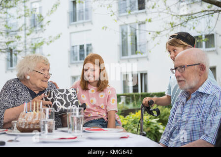 Ältere Frau mit Geschenk auf dem Tisch Stockfoto