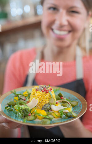 Portrait von Frau mit garniert Reisgericht in der Hand Stockfoto
