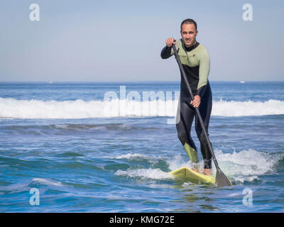 Mann beim Surfen mit einem Stand Up Paddling Board in sopelana Strand Stockfoto