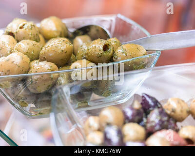 Grüne und schwarze Oliven in Glasschale Stockfoto