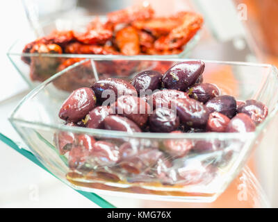 Schwarz griechischen Stil Oliven und getrocknete Tomaten in Glas Schüssel Stockfoto