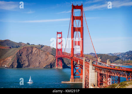 Die Golden Gate Bridge, San Francisco, am späten Abend Sonne, mit einem Segelkatamaran unter in die Bucht zu geben.. Stockfoto