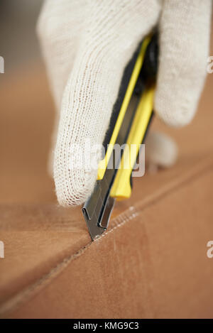 Öffnen mit Papier Messer schließen. Hand in Hand mit Messer auspacken Stockfoto