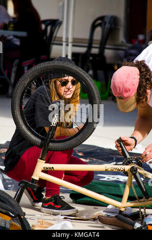 Mädchen geholfen durch junge, Rad reparieren, BMX-Fahrer bei Skate Park, während Freestyle Wettbewerb, Fuengirola, Spanien. Stockfoto