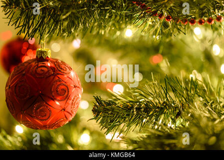 Schöne Weihnachten Hintergrund - rote Kugeln auf einem Hintergrund von verschwommen Lichter am Weihnachtsbaum mit bokeh Wirkung. Stockfoto