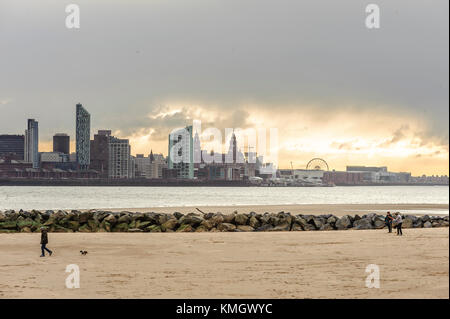 New Brighton, Wirral, Großbritannien. 8. Dezember 2017. Die Besitzer ihre Hunde Spaziergang am Strand als starker Wind und Regen hits New Brighton, auf dem Wirral Peninsula, fang am Ende des Sturms Caroline. Cloud bricht über Liverpool in der Ferne. Credit: Paul Warburton/Alamy leben Nachrichten Stockfoto