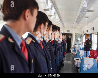 (171209) -- URUMQI, 9. Dezember 2017 (Xinhua) -- Dirigent Zhang Zhihao (1. R) arbeitet am Zug zwischen Kashgar und Hotan in der autonomen Region Xinjiang Uygur im Nordwesten Chinas, 25. November 2017. Die 485 km lange Eisenbahnstrecke verbindet die beiden großen Oasenstädte Kashgar und Hotan, führt durch einige der abgelegensten Gegenden in Xinjiang und hat das Leben in der Wüste seit ihrem Start im Jahr 2011 verändert. Es ist die erste und einzige Eisenbahnstrecke in Hotan, über die die unterentwickelte Präfektur mit dem restlichen Eisenbahnnetz des Landes verbunden ist, das über 22.000 km Hochgeschwindigkeitsstrecken verfügt. Schlechter Transport Stockfoto