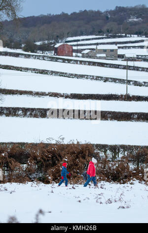 Flintshire, North Wales, UK, Dezember 2017 Wetter. Arctic chill und Met Office, der die gelbe Warnlampe für Flintshire für starke Ansammlungen von Schnee in Flintshire als Menschen den Hügel nach als Tag der Rodeln im Dorf Rhes-y-Cae, Flintshire verlassen Stockfoto