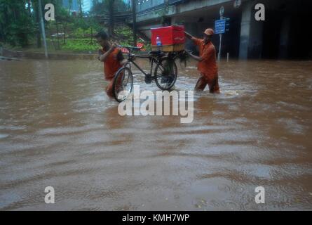 (171211) -- JAKARTA, Dez. 11, 2017 (Xinhua) - Mitglieder der öffentlichen Einrichtung Maintenance Agency (PPSU) versuchen ein Fahrrad aus einem Überflutete Straße in Jakarta, Indonesien, Dez, 11. 2017. Heavy Rain von mehreren Stunden links waterlogged Straßen und verursacht Staus in einigen Bereichen von Jakarta. (Xinhua / Zulkarnain) (zjl) Stockfoto