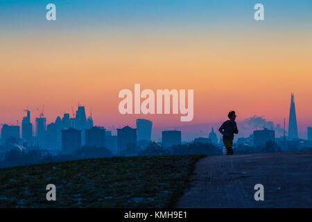 London, Großbritannien. 12 Dez, 2017. London, 12. Dezember 2017. Ein Läufer erreicht die Spitze der Primrose Hill Milben vor dem Sonnenaufgang auf einem klaren sehr kalten Morgen in London. Credit: Paul Davey/Alamy leben Nachrichten Stockfoto